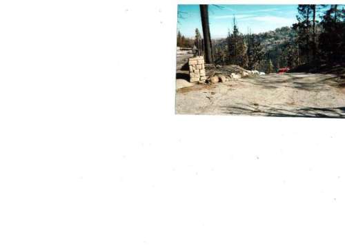 Standing in our driveway, looking down access road. Fire chief's car but no more houses. Note burnt canyons.JPG